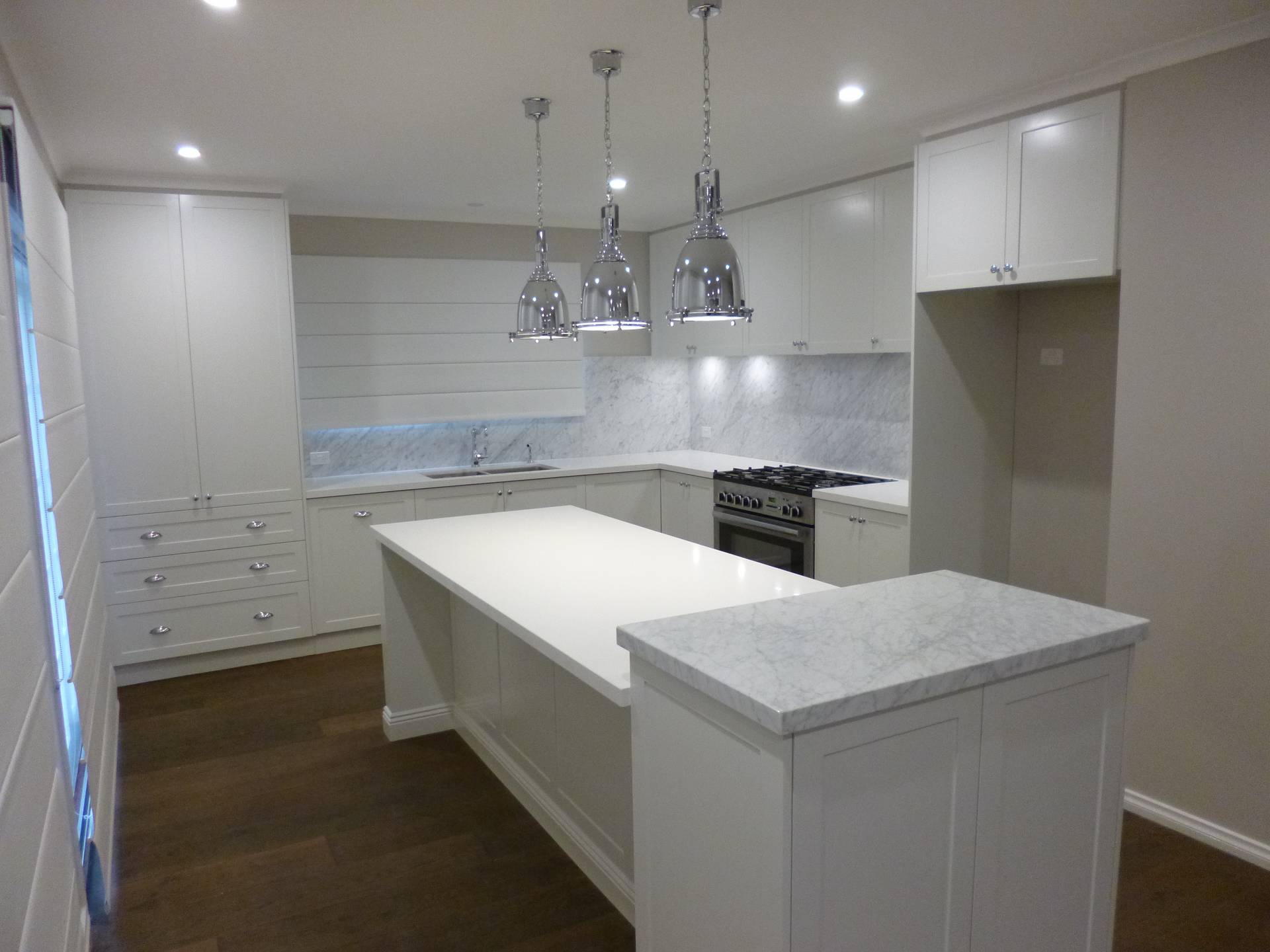 Hampton style kitchen, timber floors and industrial style pendant lights creating a stunning kitchen.